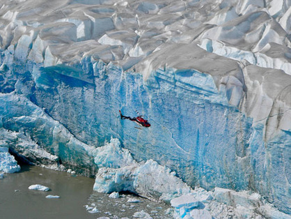 Helicopter flying by glacier
