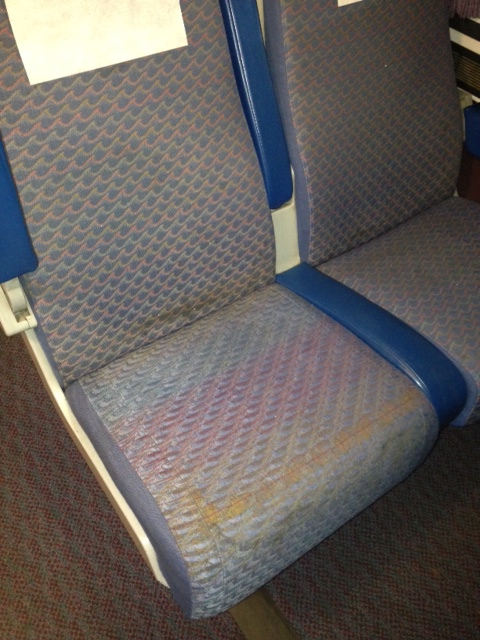 Train seat damaged by wear and dirt from shoes