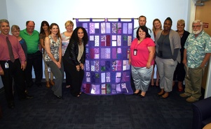 SunCoast Region Adult Protective Services staff with quilt.