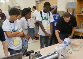 a group of campers at the University of South Florida Robotics Lab learning how robots respond to commands.