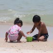 Two children play on the beach.