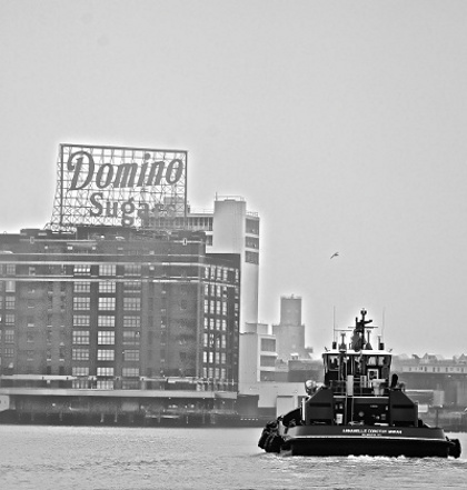 IMAGE: A boat floats on Baltimore's harbor toward Domino Sugars