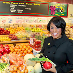 IMAGE: Mayor Rawlings-Blake purchases vibrant produce from a vendor at Northeast Market