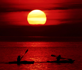 Photo of kayakers at sunset
