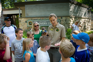 Michigan Department of Natural Resources employee talks to students outside the Eddy Discovery Center in Chelsea