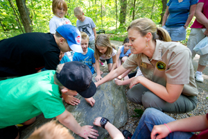 Students exploring the features of a large rock