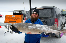 Man holding lake sturgeon at Black Lake