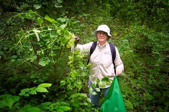 woman wearing a hat and outdoor gear in a forested area