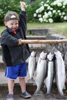 Kid holding stick with hanging salmon