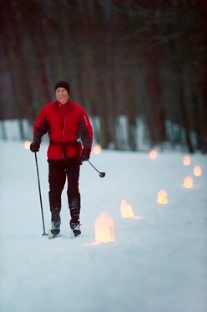 man cross-country skiing by candlelight