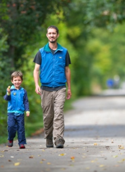 Man and boy walking on a trail in spring