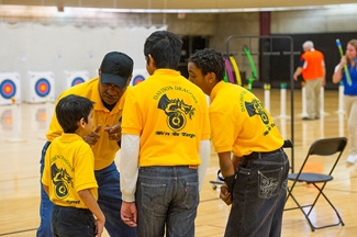 Coach giving students archery pointers