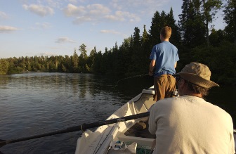 man and boy fishing off of a boat