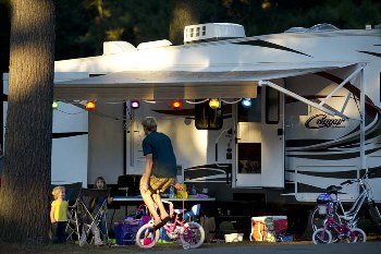 Family sitting outside a motorhome at a Michigan state park campground