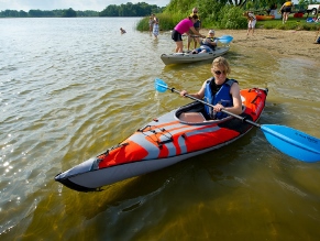 Woman launching a kayak from shore