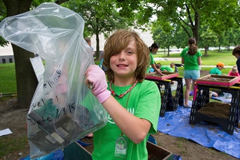 young boy holding up items from archaeological dig