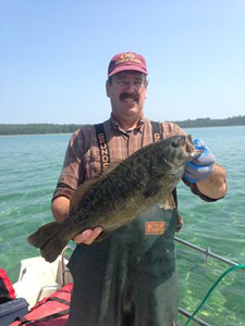 Tagged smallmouth bass being held by DNR employee