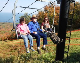 People on chairlift to enjoy fall color at the Porkies