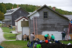 volunteers painting exterior of a Fayette building