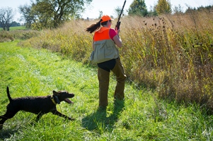 hunter and dog head into tall grass