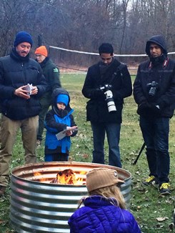 Participants of the Owl Prowl hike gather around a campfire to get warm.