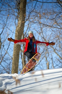 woman snowshoeing in wooded area