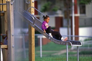 girl sliding down slide on playground