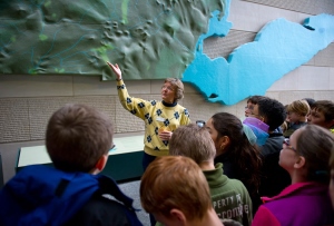 museum volunteer talks to school kids