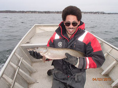 DNR fisheries employee holding up northern pike caught during survey on Devils Lake