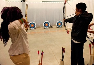 boy and girl shooting bow and arrow at archery range