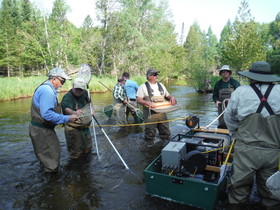Individuals working together on surveying North Branch of Au Sable River