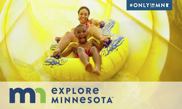 Mother and son ride an indoor water slide together