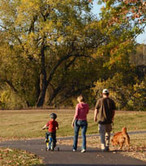 Family walking on trail in autumn.