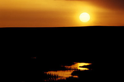 Golden sun sets over the river.