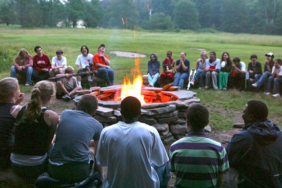 A group of kids around a campfire.