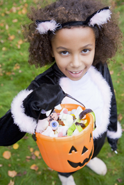 Young girl outdoors in cat costume on Halloween 
