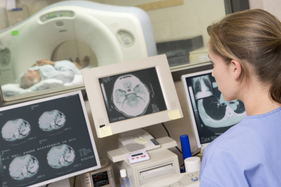 Nurse monitors patient having a computerized axial tomography (CAT) scan