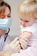 Female doctor gives toddler girl an injection
