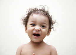 Adorable Indian baby laughing. Shows baby teeth.