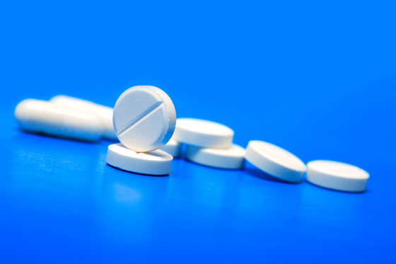 Extreme closeup of few white pills on blue background 