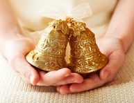 Child's hands holding glittering golden bells