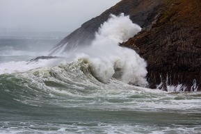 Ocean waves crash on rocks. 