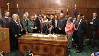 Sen. Riley and colleagues gathered around Gov. Brown as she signs SB 941
