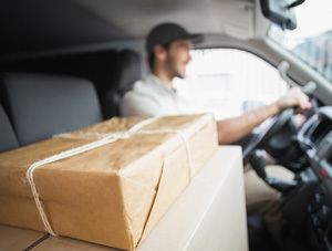 Photo of a delivery driver and various parcels.