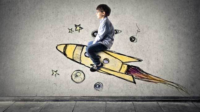 Photo of a boy riding a cartoon rocket ship
