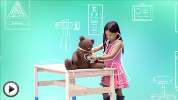 Photo of a child playing doctor with her teddy bear