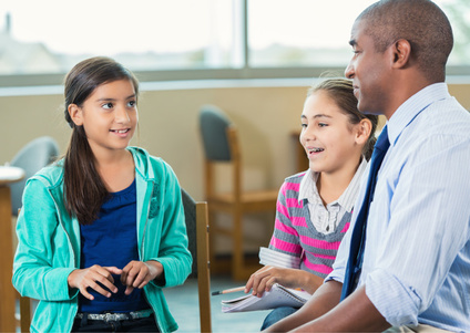 Image of mentor working with two children.