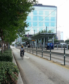 A rider passes the Downtown Transit Center's bike share stand