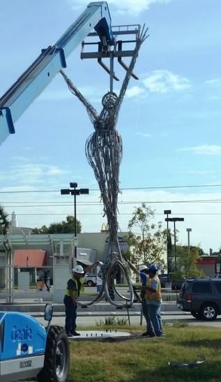 Workers install Jesse Lott's Spirit of Transportation sculpture