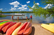 many colorful canoes with a family setting out